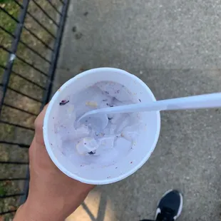 a person holding a cup of ice cream
