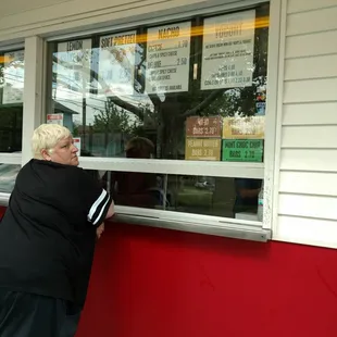a woman leaning against a window