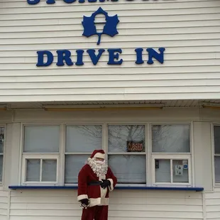 santa standing in front of a store