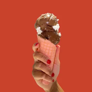 a hand holding an ice cream cone