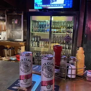 two cans of beer on a bar