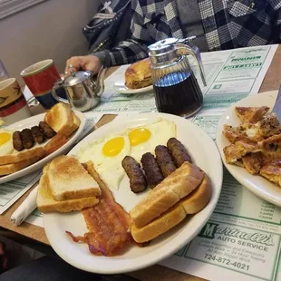 a breakfast of eggs, bacon, toast, and sausage