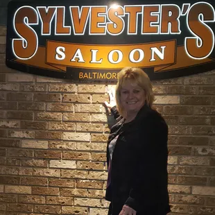 a woman standing in front of a sign