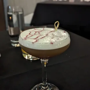 a cocktail in a coupe glass on a table