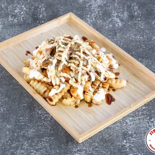 a plate of fries with a drizzle of sauce on top