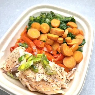 health lunch box with salmon, carrots, kale, bell pepper