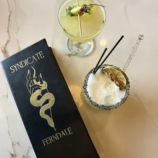 a glass of lemonade and a book on a table