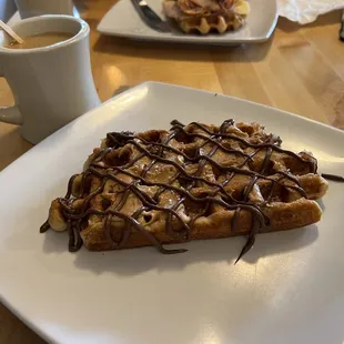 a plate of waffles and a cup of coffee