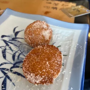 two sugar coated donuts on a plate