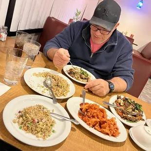 a man sitting at a table with plates of food