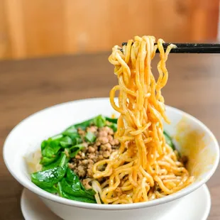 a bowl of noodles with chopsticks