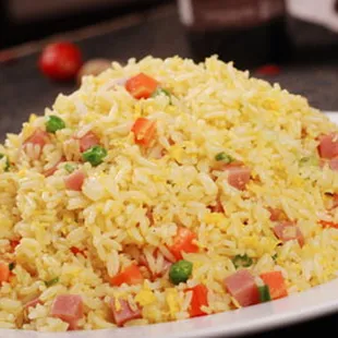 a plate of rice with ham and peas