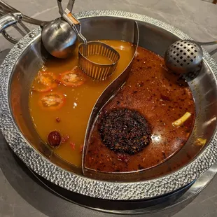 Yin Yang Pot. Left is Organic Tomato Pork Broth. Right is Beef Tallow Mala Hotpot.