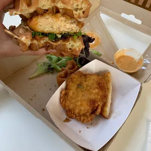 a hand holding a half eaten sandwich