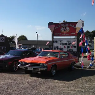 several classic cars parked in a parking lot