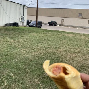 a hand holding a half eaten donut