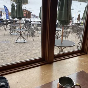 a cup of coffee on a table in front of a large window
