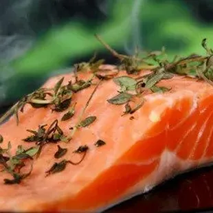 a piece of salmon on a black plate