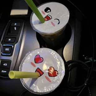 two cups of coffee with faces drawn on them