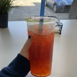 Raspberry/orange boba with a green tea base and pomegranate bobas