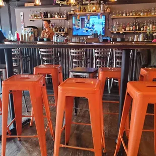 a bar with orange stools