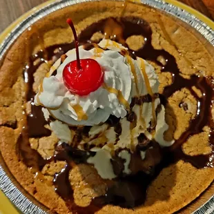  a chocolate chip pie topped with whipped cream and a cherry