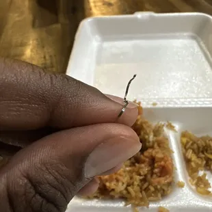 a hand holding a fork with food in it