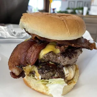 a hamburger with bacon, cheese, and lettuce