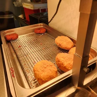 a tray of fried donuts being prepared
