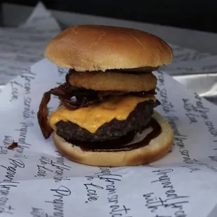 Carolina Burger- Angus beef patty topped w/ American cheese, bacon, onion ring, barbeque sauce served on a brioche bun.