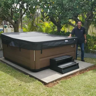 a man standing next to a hot tub