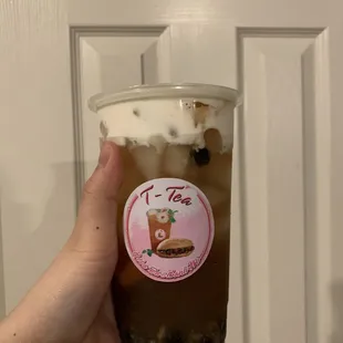 a hand holding a cup of iced coffee