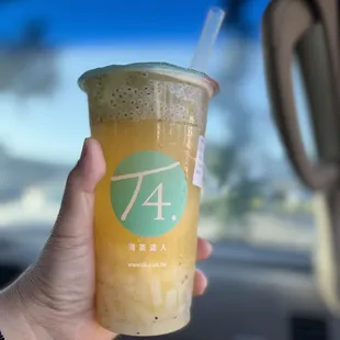 a hand holding a cup of iced tea