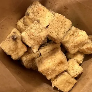 a brown paper bag filled with pieces of bread