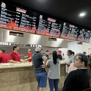 a group of people standing in line at a fast food restaurant