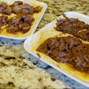 two trays of food on a granite countertop