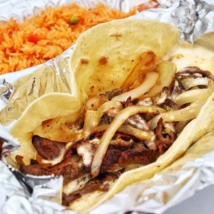 Mexican Cheese-Steak:  Flour tortilla, steak, grilled onion, melted cheese and a side of rice.