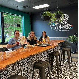 three people sitting at a bar