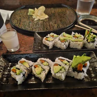 two plates of sushi with chopsticks
