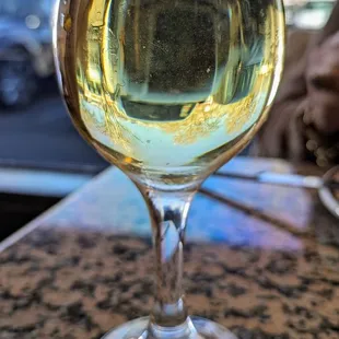 a glass of white wine on a table