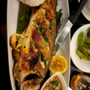 a plate of fish with rice and vegetables