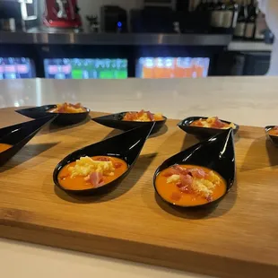 five spoons of food on a cutting board