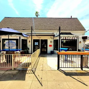 the outside of a restaurant with tables and umbrellas