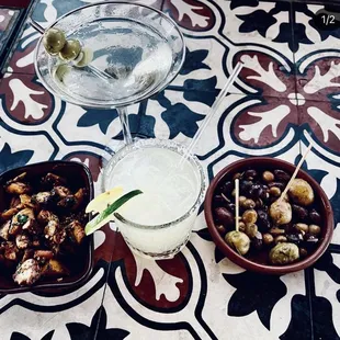 a cocktail, olives, and a bowl of olives