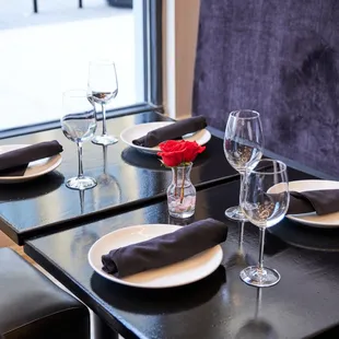 a table setting with wine glasses and napkins