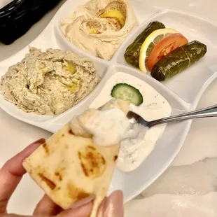 a hand holding a piece of pita
