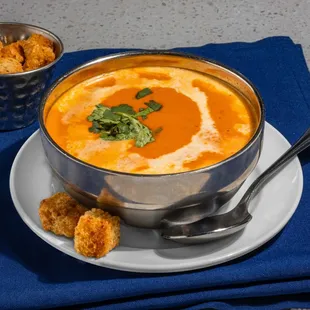 Tomato Shorba - a blend of tomato puree and onion, topped with cream and croutons