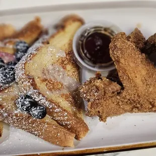 a plate of french toast, berries, and fried chicken