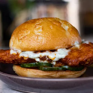 Buffalo Chicken Sandwich | breaded chicken tenders tossed in buffalo sauce, housemade pickles, grilled bun, bleu cheese aioli (GF available)
