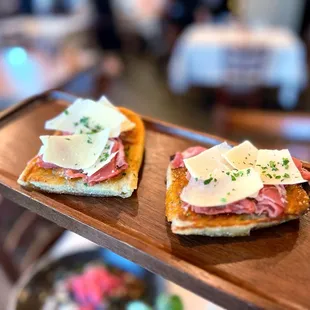 two slices of bread topped with cheese and meat